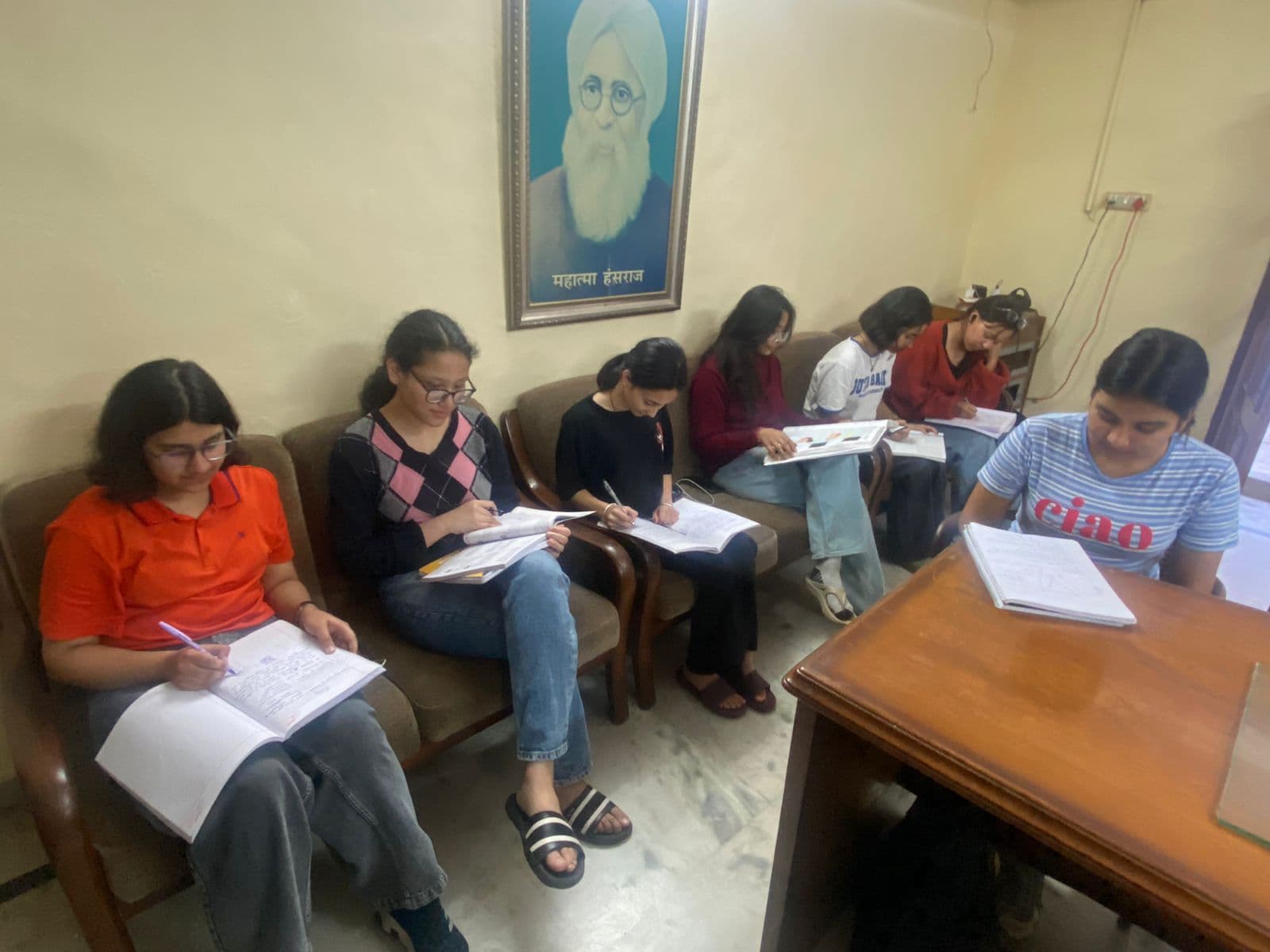 Hostel residents studying under the portrait of Mahatma Hansraj — DAV founder